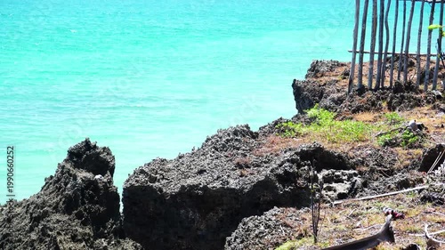 Rocky Volcanic Coastline with Turquoise Ocean and Traditional Wooden Fence - 4K footage