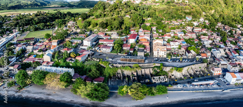 panoramic aerial landscape view of area around central part of Saint-Pierre - with colorful houses, black sand beach and 