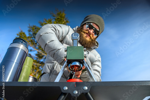 Manual lever espresso brewing outdoors, portable coffee machine in mountains, barista pressing lever, winter setup