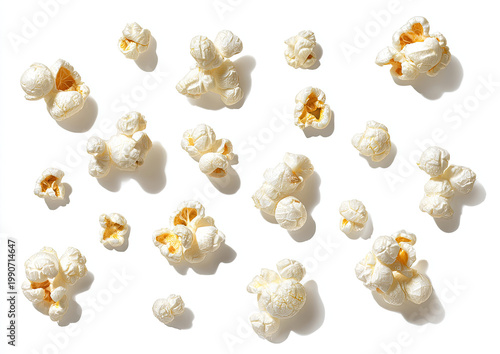 Scattered kernels of fluffy, white snack food cast shadows on a white background