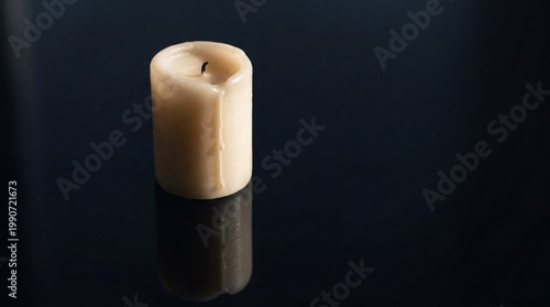 Single Cream Pillar Candle with Melted Wax Drip on Dark Reflective Background