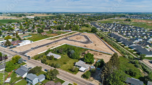 Aerial View of New Residential Subdivision Under Construction Adjacent to Established Suburban Neighborhood in Summer