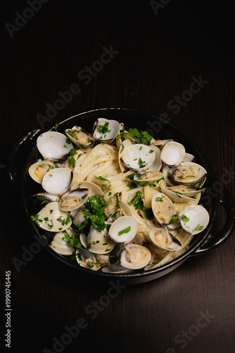 Freshly cooked spaghetti alle vongole with garlic and olive oil in rustic style