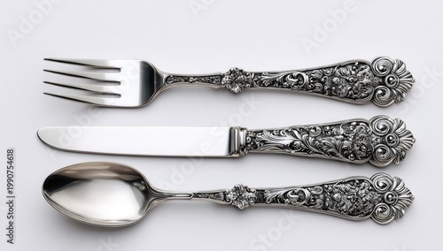 Ornate silver cutlery set fork, knife, and spoon with intricate floral details