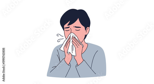 A sick young man wearing a simple grey long-sleeved shirt holds a crumpled white tissue over his nose while sneezing against a plain white backdrop.