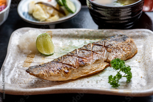 Tableau sur toile A plate of grilled fish with lemon and parsley.
