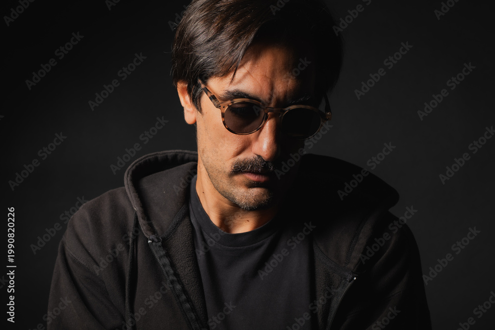 Obraz premium Mysterious man in shades deeply lost in thought, creating an enigmatic vibe