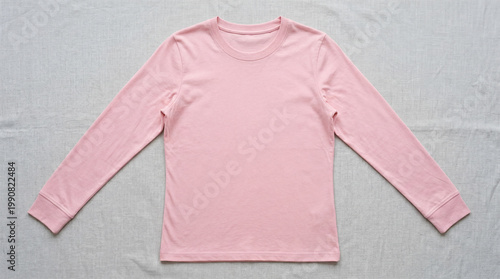 A pink long-sleeved shirt laid out on a light gray background