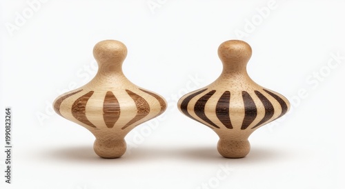 Two wooden spinning tops with contrasting striped wood patterns against white