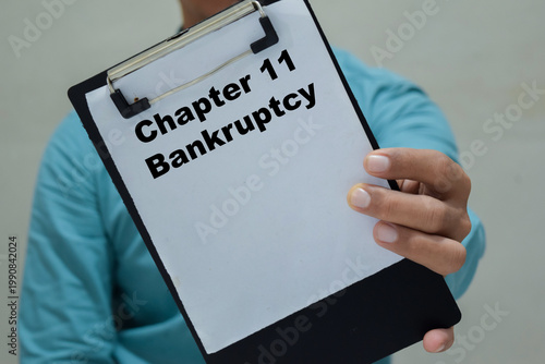 Foto Businessman holds in hands a clipboard with the name of the chapter 11 bankruptcy