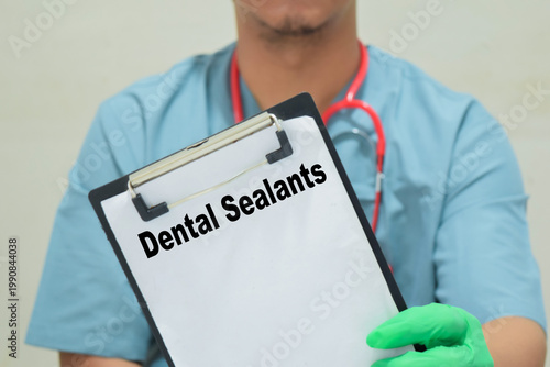 Doctor holds in hands a clipboard with the name of the dental sealants. Medical concept