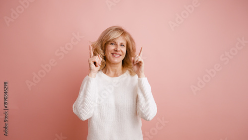 Photography Adult woman smiling, enthusiastically pointing both index fingers upwards, sugge