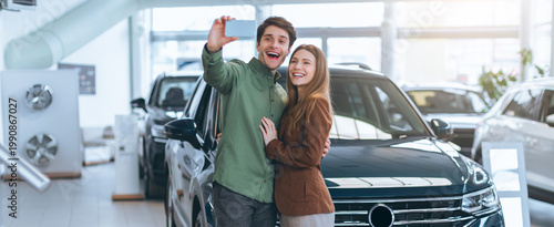 Bild auf Leinwand A couple stands close together in a car dealership