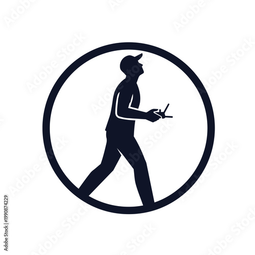 A man wearing a baseball cap walks while holding a drone controller in a circle.