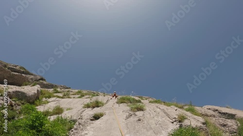 Man Rock Climbing on High Mountain Cliff in Slow Motion
