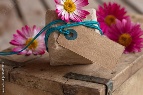 Cute little gift package with cardboard label and space for text on old wood – Mother's Day – Birthday