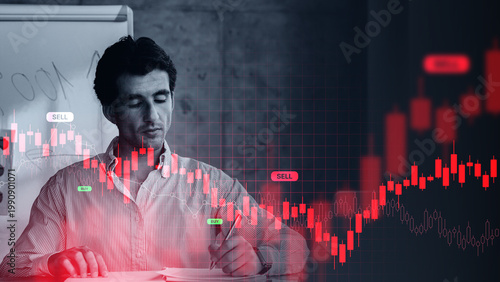 Photos A trader focuses on stock market charts and graphs while taking notes
