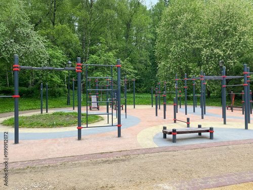 Outdoor calisthenics workout area with pull-up bars in public park. Street workout station featuring metal horizontal bars. Modern fitness equipment located in green park