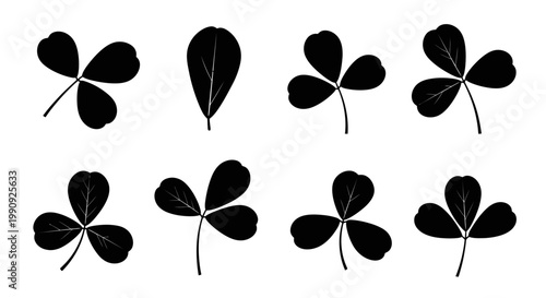 Collection of black silhouettes of clover leaves and a single oval leaf on a clean white background representing luck nature and simplicity in graphic design elements