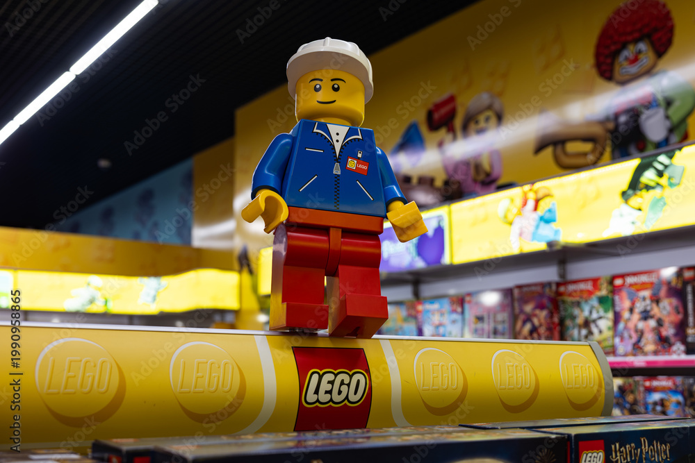 Fototapeta premium LEGO worker minifigure on yellow display shelf in store