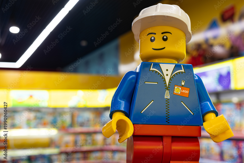 Fototapeta premium LEGO worker minifigure on yellow display shelf in store