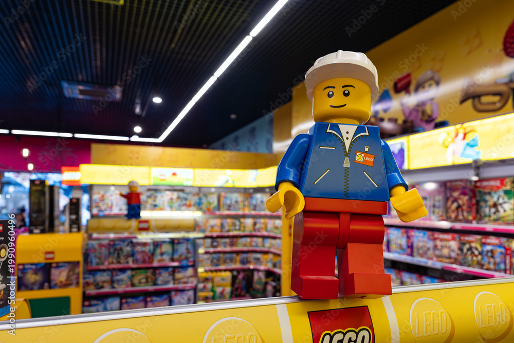 Fototapeta premium LEGO worker minifigure on yellow display shelf in store