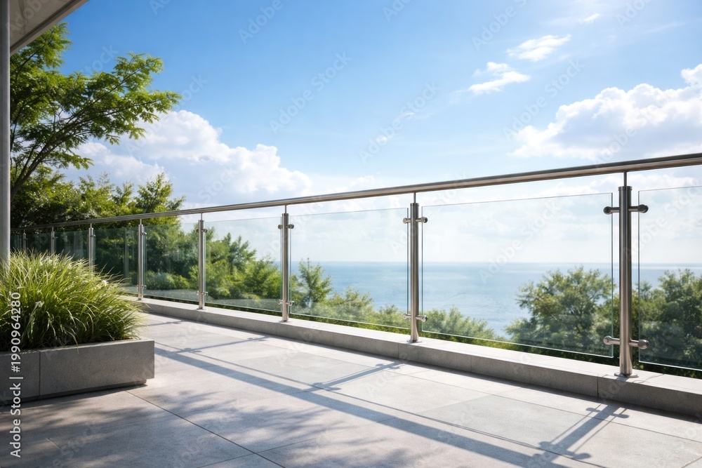 Fototapeta premium Elegant modern glass terrace balustrade with sleek stainless steel railing under bright summer sky
