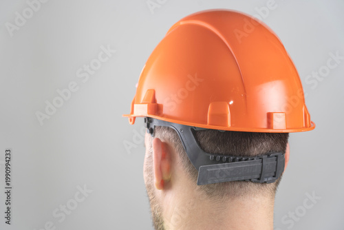Close-up of a man in an orange construction helmet.