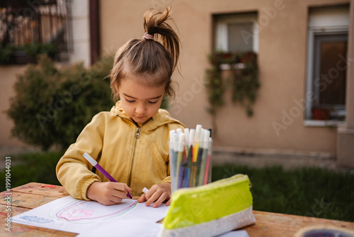 Εκτύπωση καμβά Young girl drawing on paper with marker pens outdoor