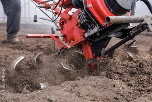 Bilde på lerret Rotary tiller blades digging and loosening soil for seedbed preparation in green