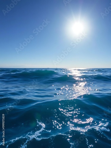 Vast, serene blue ocean waves gently rolling towards a clear horizon under a bright sun,  sky,  sea