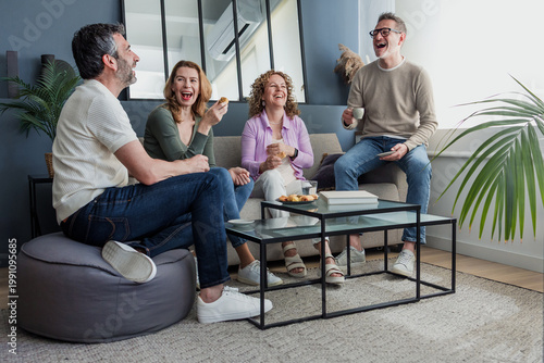 group of senior friends having fun at home, Diverse group of hispanic middle aged people on sofa indoors
