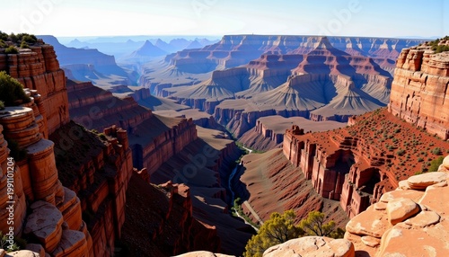 Stunning Aerial View of Expansive Red Rock Canyon Landscape with Dramatic Cliffs, Deep Ravines, and Unique Layered Formations Under a Clear Blue Sky