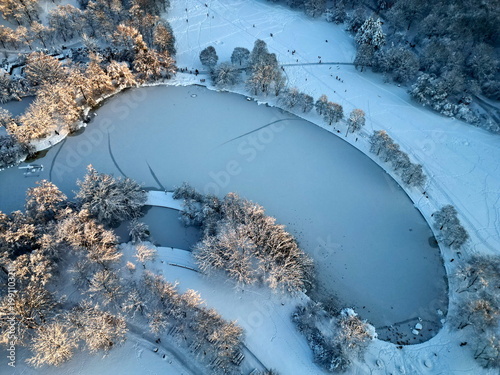 Fotografie Aerial view of frozen Mollsee lake with ice tracks in Westpark Munich