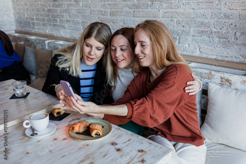 group of young hispanic women friends enjoying a coffee cup in a coffee shop indoors