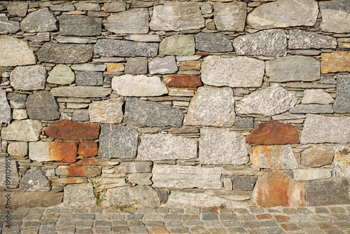 Neat fieldstone masonry wall texture rustic mixed stone background facade