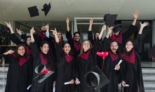 Fotografía group of young Latinos graduates students throwing their graduation caps and cel