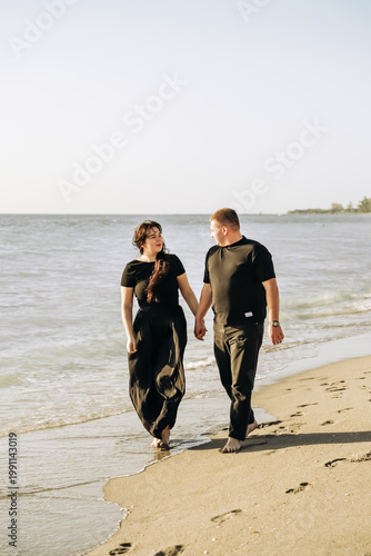 Happy young couple hugging on the beach, summer love concept.