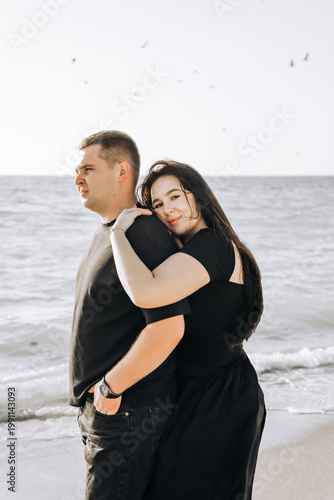 Happy young couple hugging on the beach, summer love concept.