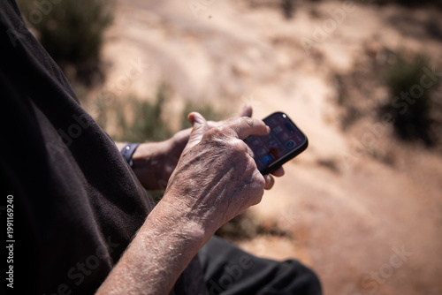 Elderly Person Using Smartphone Outdoors Desert