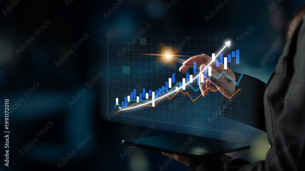 Obraz premium A businesswoman engages with financial data through a laptop, showcasing virtual graphs that indicate market trends and growth opportunities. Impute