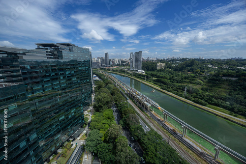 Sao Paulo city in Brazil with a park, buildings, and Pinheiros river crossing the city. Marginal Pinheiros avenue with traffic during daylight