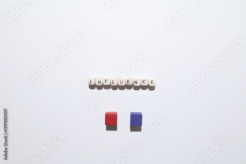Fotografie INFLUENCE text with red and purple cubes representing power, persuasion and impact between opposing groups