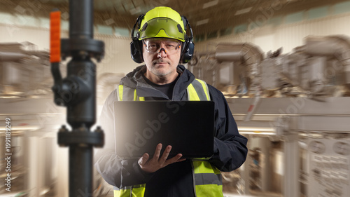 Industrial plant, Technical inspection. Engineer in protective gear checks equipment and pipeline systems with laptop, monitoring production and maintenance processes.