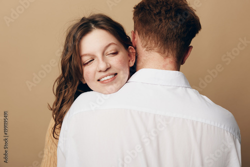 Photography Smiling woman with closed eyes hugs man wearing white shirt from behind