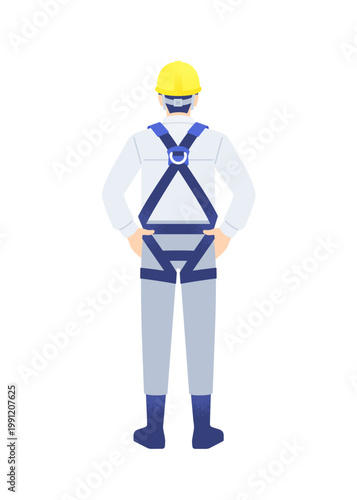 フルハーネスを装着した現場監督の男性が腰に手を当て現場を確認している様子 全身の後ろ姿