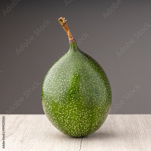 Passiflora ligularis - Unripe green passion fruit on a wooden table