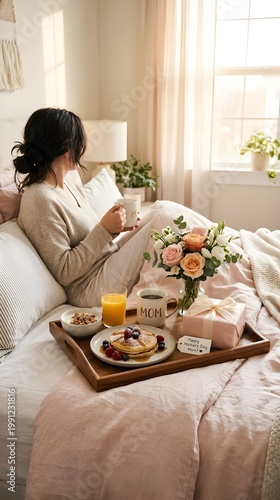 Mother’s Day breakfast in bed with pancakes flowers and gift in soft morning light