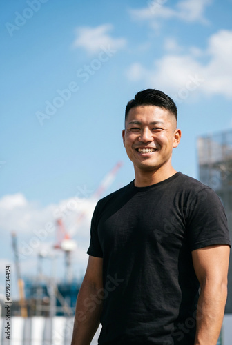 建設現場を背景にしたたくましい男性のポートレート 笑顔 コピースペース 求人イメージ