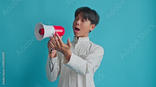 Excited Muslim teenager holding loud hailer and gesturing toward camera